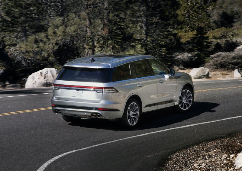 A 2023 Lincoln Aviator® Grand Touring model is shown being driven on a tight turn of a mountain road | Crossroads Lincoln of Southern Pines in Southern Pines NC