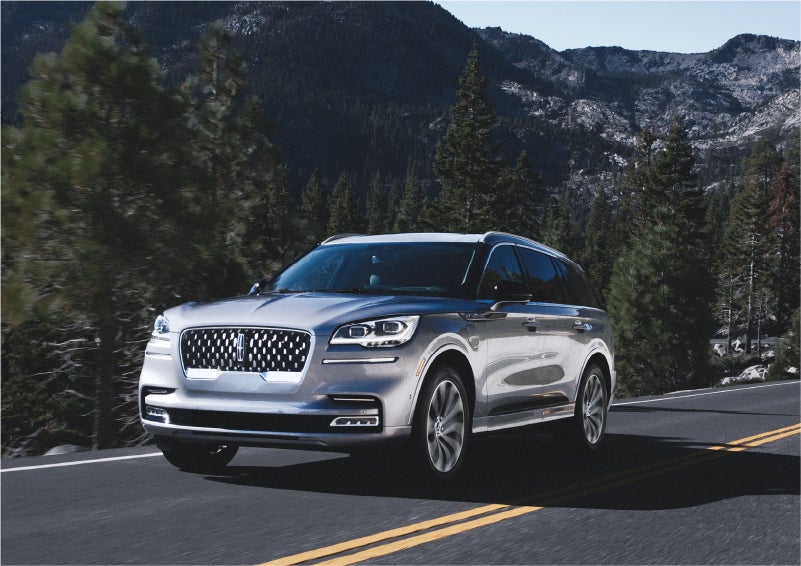 A 2023 Lincoln Aviator® Grand Touring SUV being driven on a winding road to demonstrate the capabilities of all-wheel drive | Crossroads Lincoln of Southern Pines in Southern Pines NC